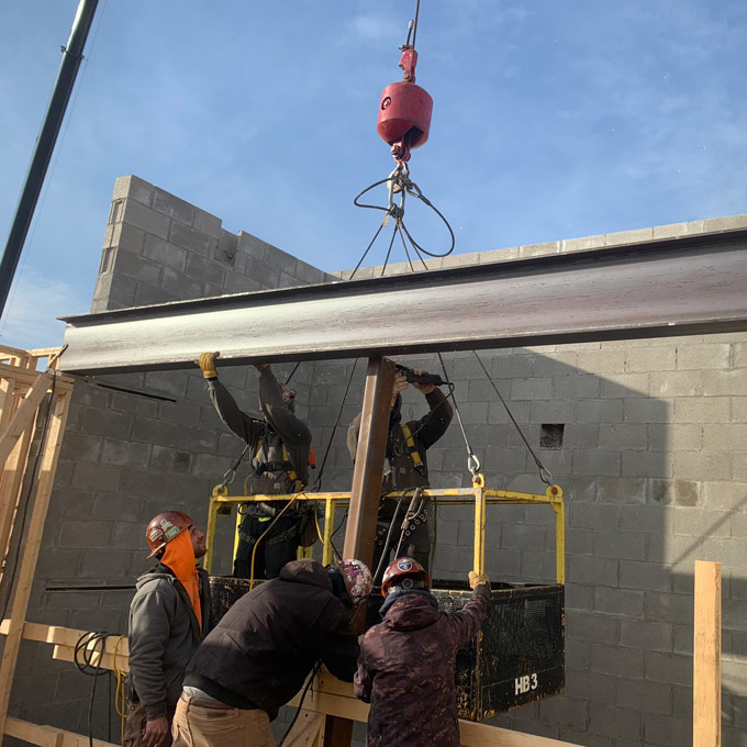 Crew installing structural steel beam